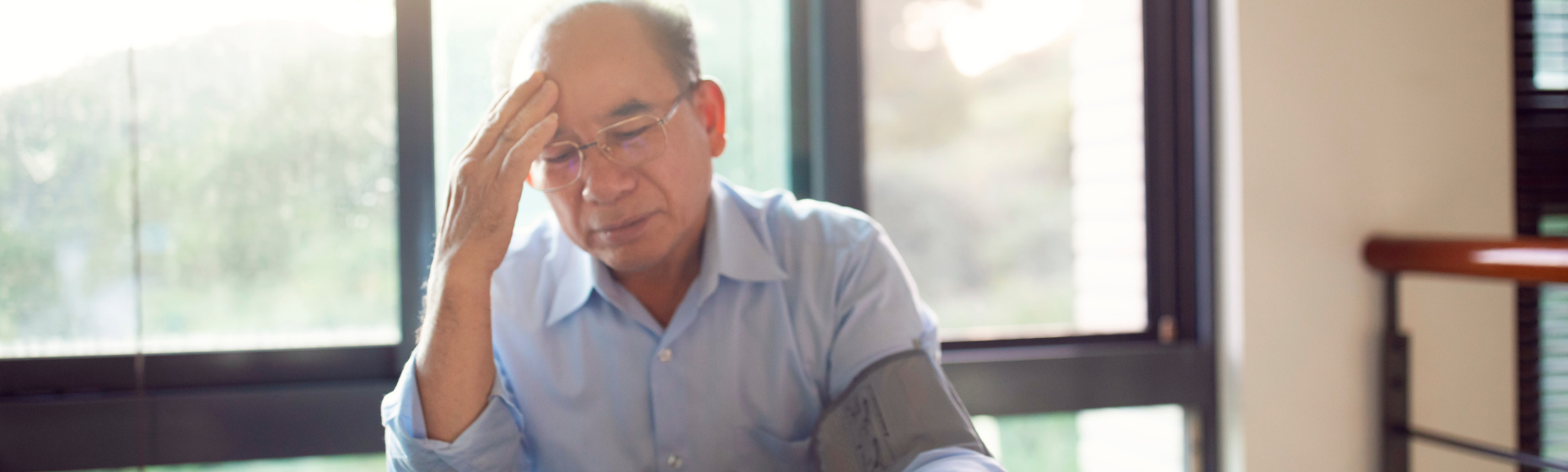 Man worried looking at Blood Pressure Monitor