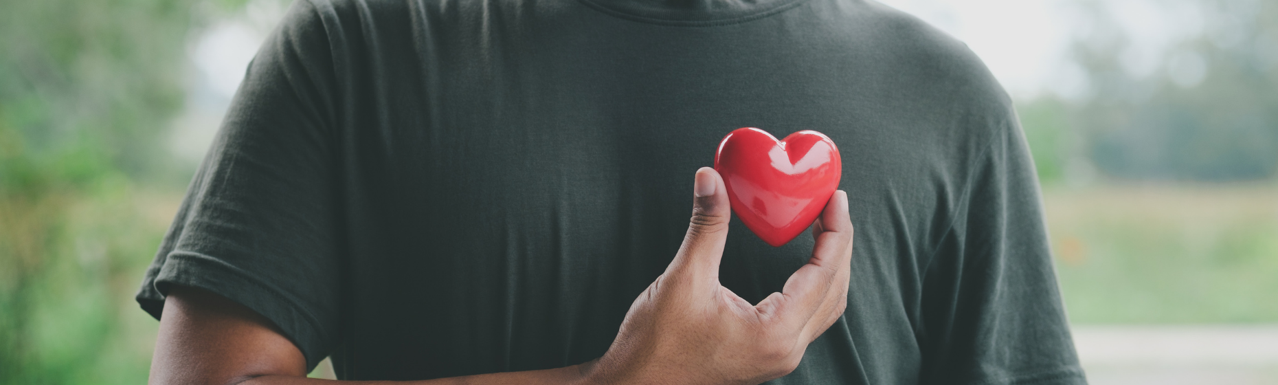 Man holding red heart over chest